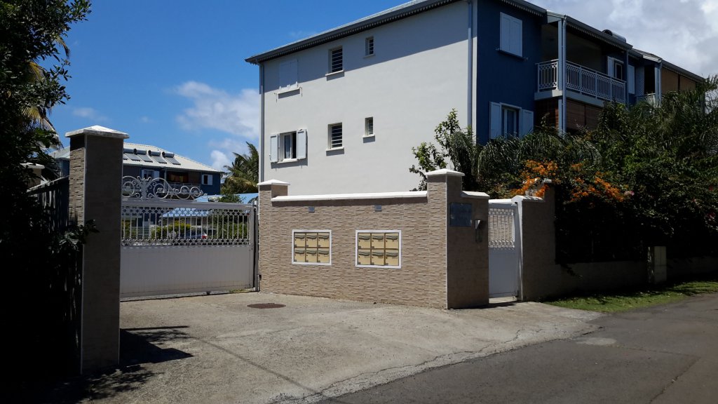 Entrée de la résidence avec le bâtiment dans lequel se situe le T3 (non visible car situé derrière le mur)